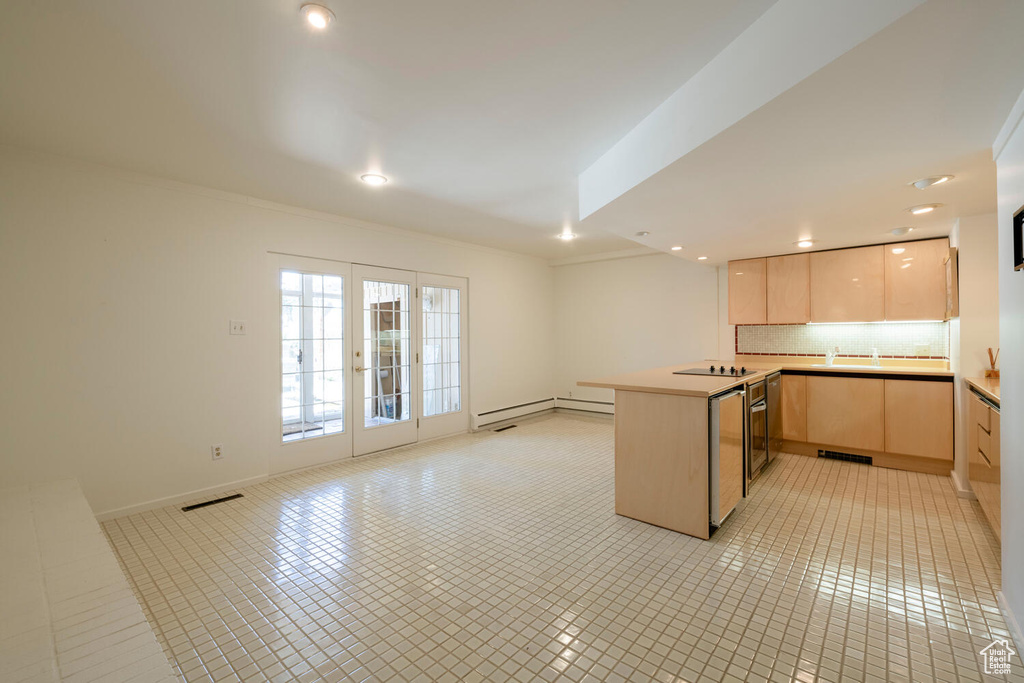 Kitchen with light tile floors, light brown cabinetry, tasteful backsplash, black electric cooktop, and french doors