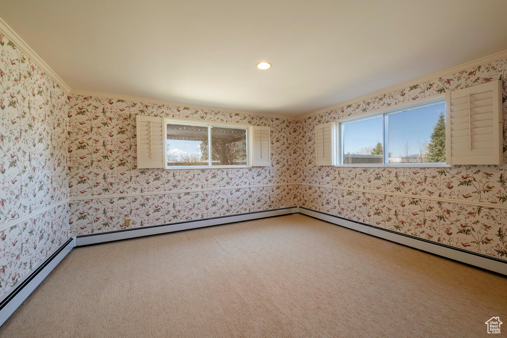 Unfurnished room with crown molding, carpet, and a baseboard radiator