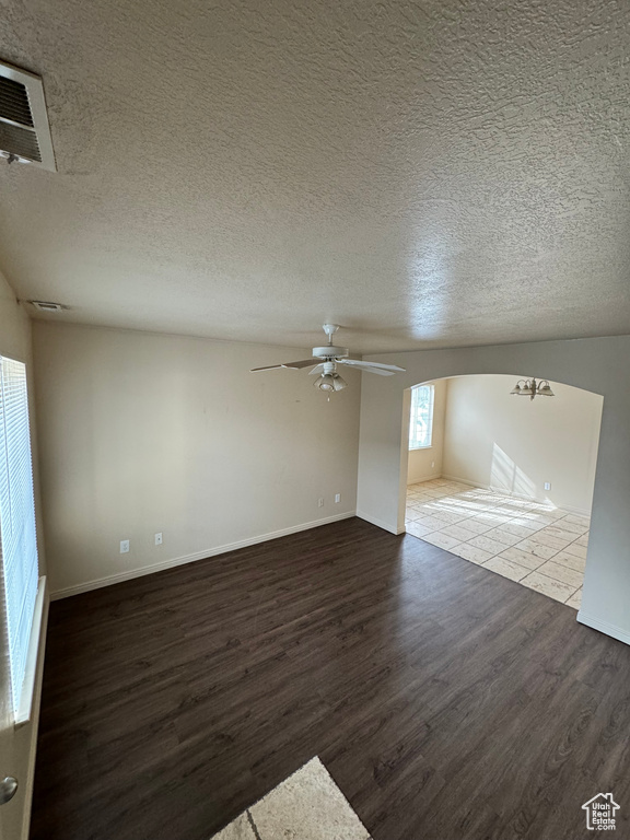 Empty room featuring light hardwood / wood-style flooring, ceiling fan, and a textured ceiling