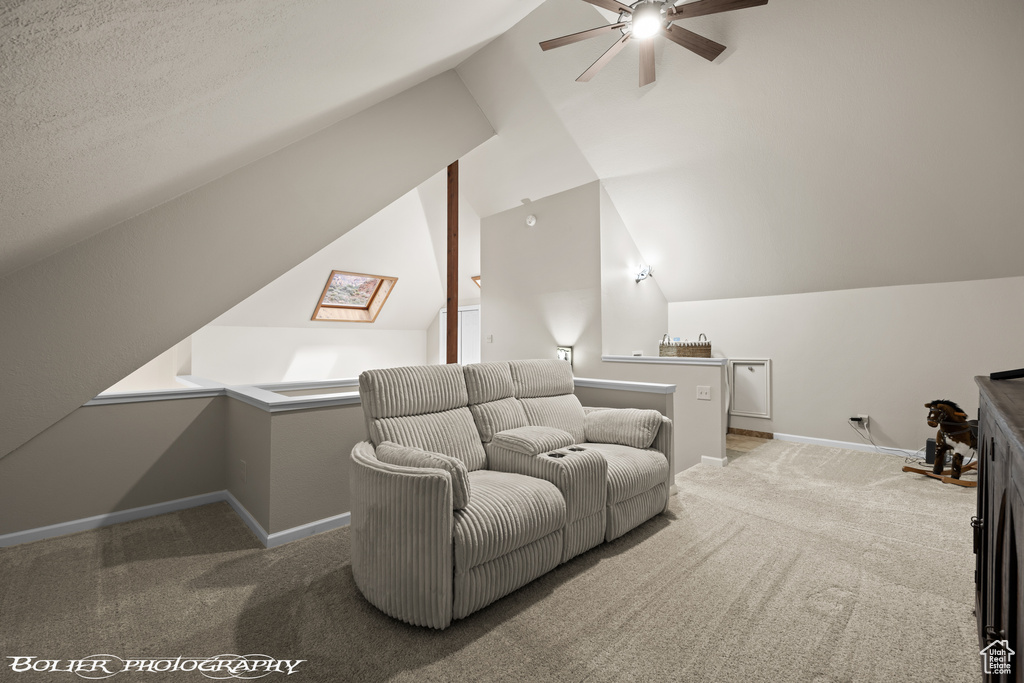 Carpeted cinema room with lofted ceiling, ceiling fan, and a textured ceiling