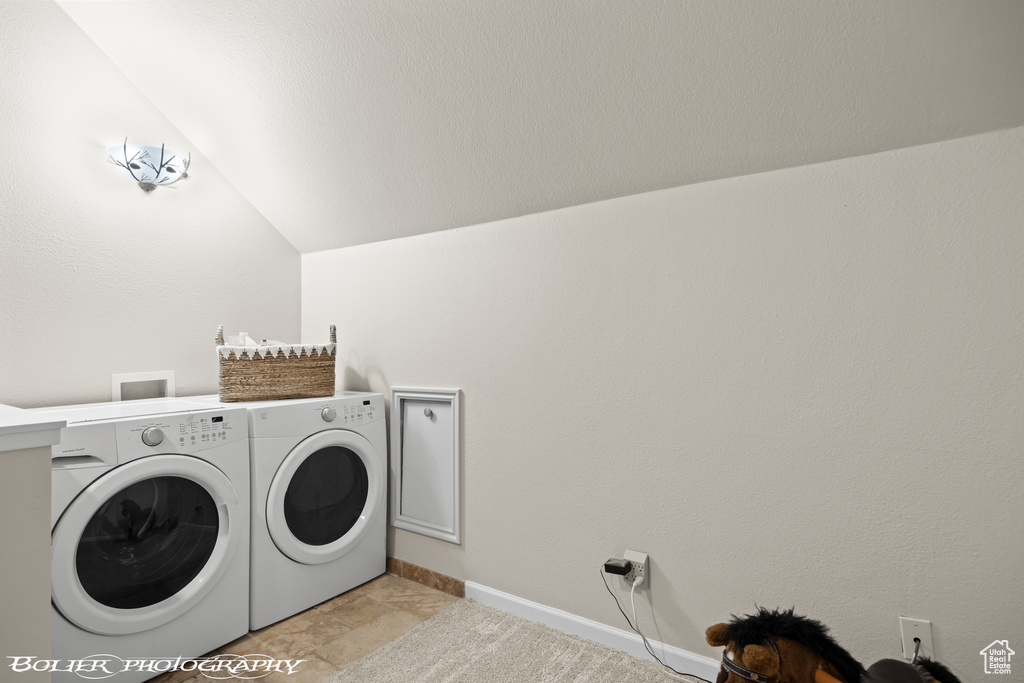 Laundry room featuring light tile flooring, washer hookup, and washer and clothes dryer