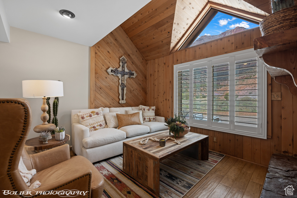 Living room featuring wood walls, dark hardwood / wood-style flooring, and high vaulted ceiling