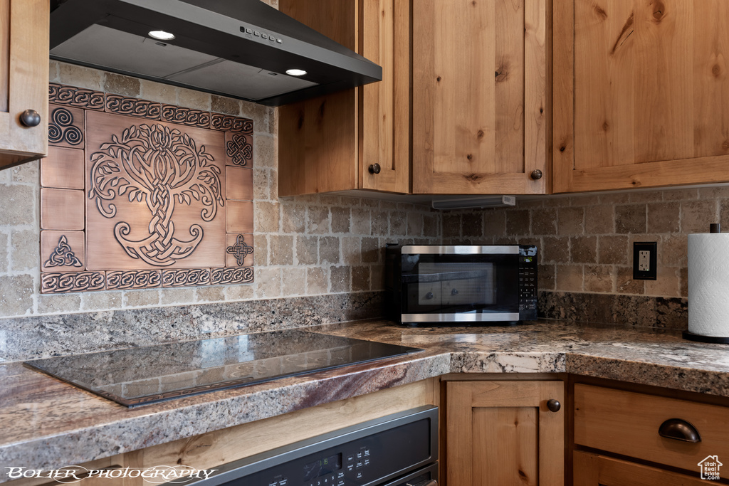 Kitchen featuring wall oven, tasteful backsplash, and black electric stovetop