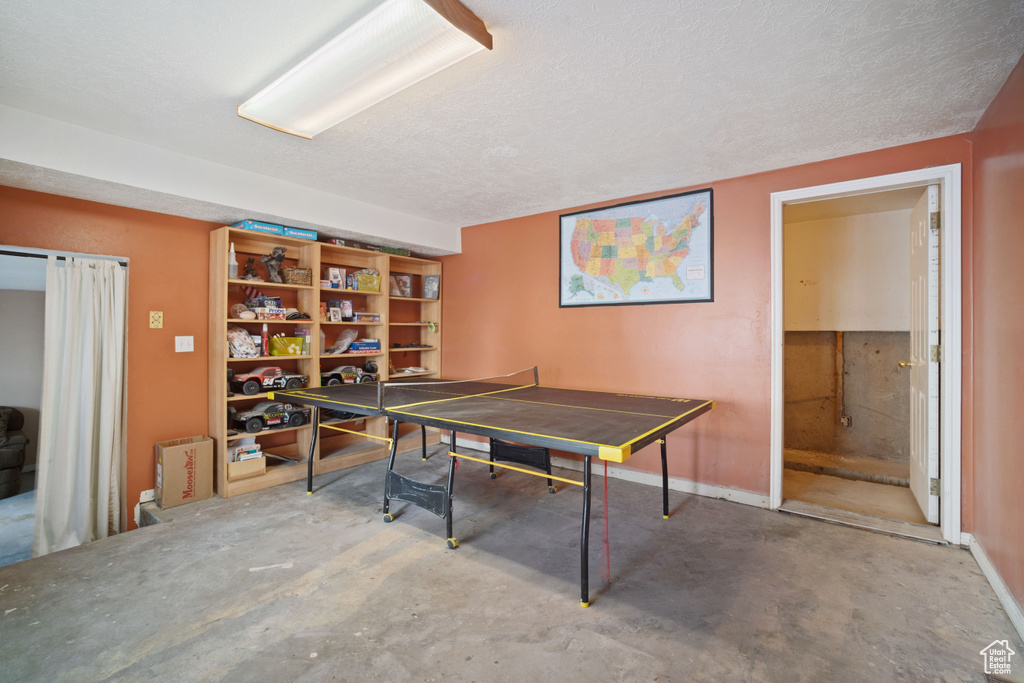 Playroom with concrete flooring and a textured ceiling