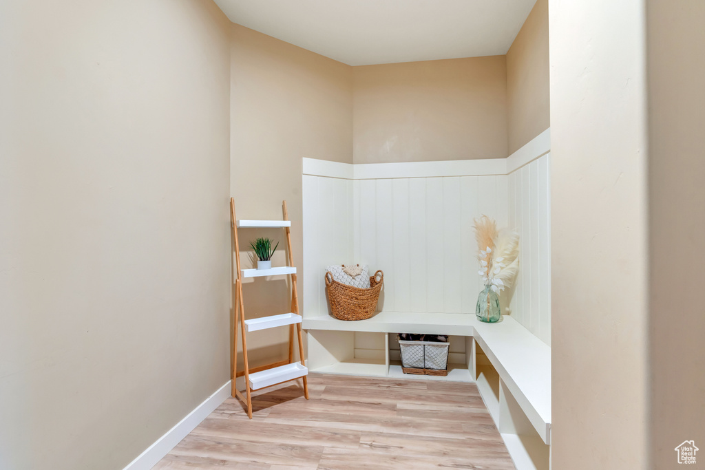 Mudroom with light hardwood / wood-style flooring and a high ceiling