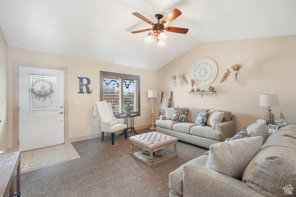 Living room with light colored carpet, ceiling fan, and vaulted ceiling