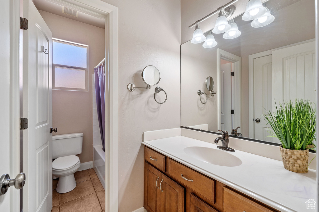 Full bathroom featuring vanity, tile floors, toilet, and shower / tub combo