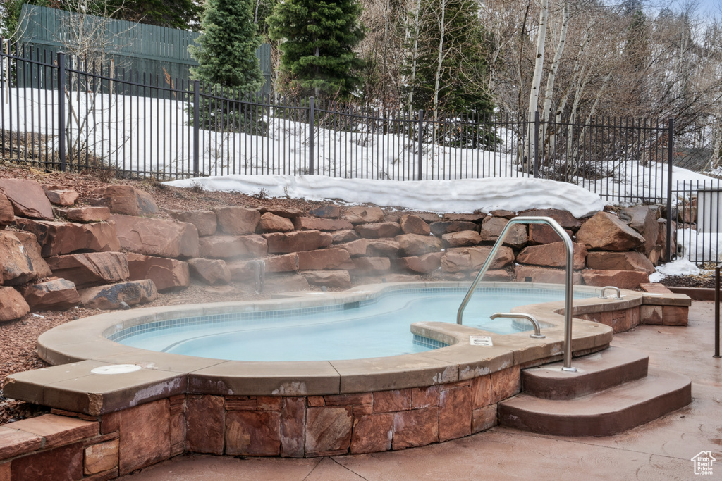 Snow covered pool with an in ground hot tub