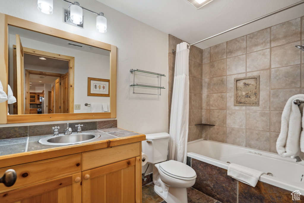 Full bathroom featuring shower / bathtub combination with curtain, toilet, tile floors, and large vanity
