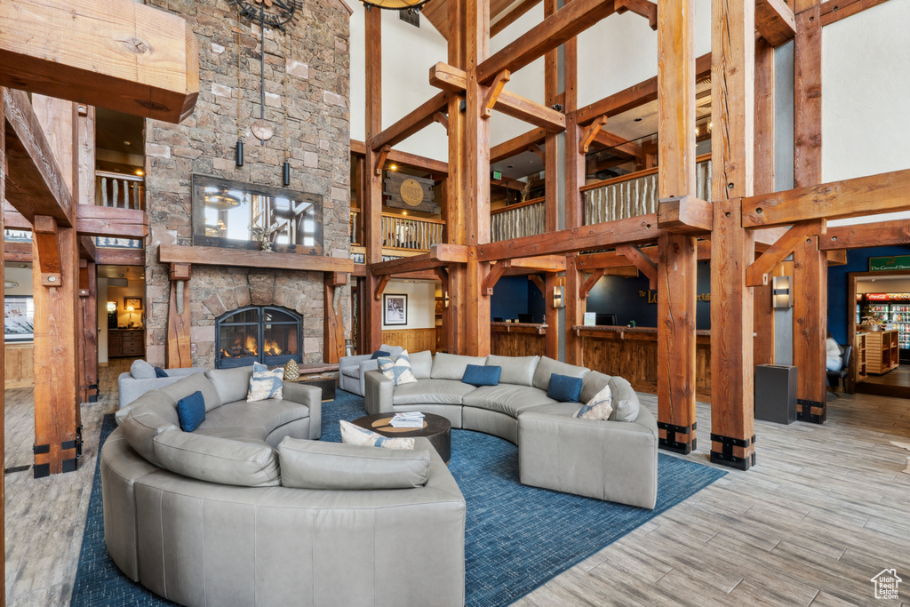 Living room featuring light hardwood / wood-style floors, a towering ceiling, and a fireplace