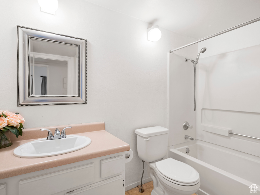 Full bathroom with vanity with extensive cabinet space, tile floors, toilet, and shower / bathing tub combination