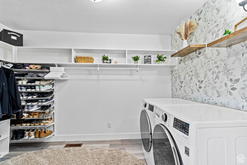 Laundry area with dark hardwood / wood-style flooring and washing machine and dryer