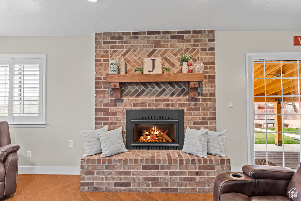 Living room featuring brick wall and a brick fireplace