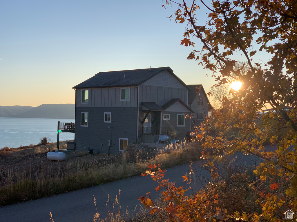 Back house at dusk featuring a water view