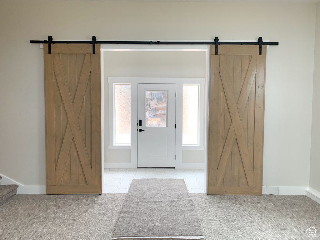 Carpeted foyer featuring a barn door