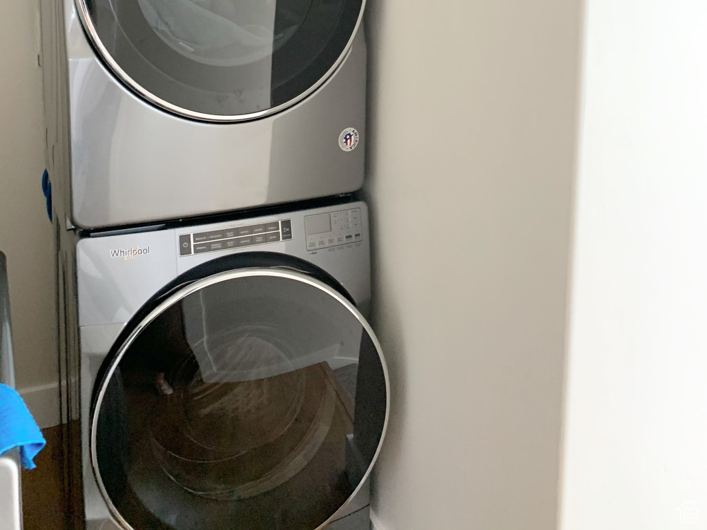 Clothes washing area with stacked washing maching and dryer and cabinets