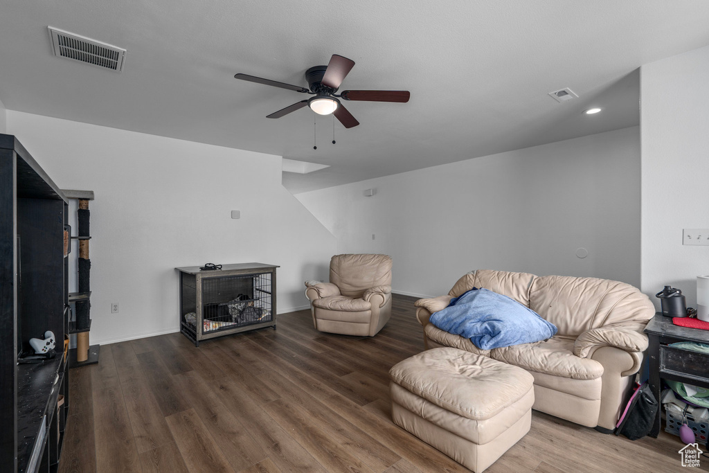 Living room with dark wood-type flooring and ceiling fan