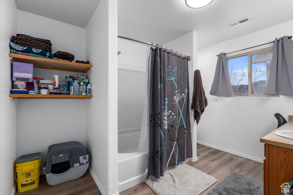 Bathroom with vanity, hardwood / wood-style flooring, and shower / tub combo with curtain
