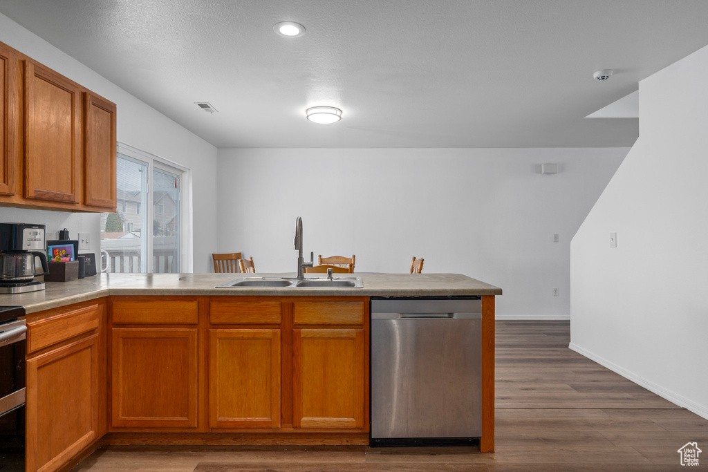 Kitchen featuring dark wood-type flooring, dishwasher, and sink