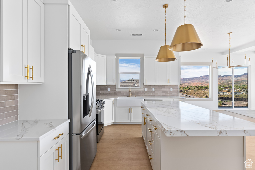 Kitchen featuring a wealth of natural light, appliances with stainless steel finishes, and a center island