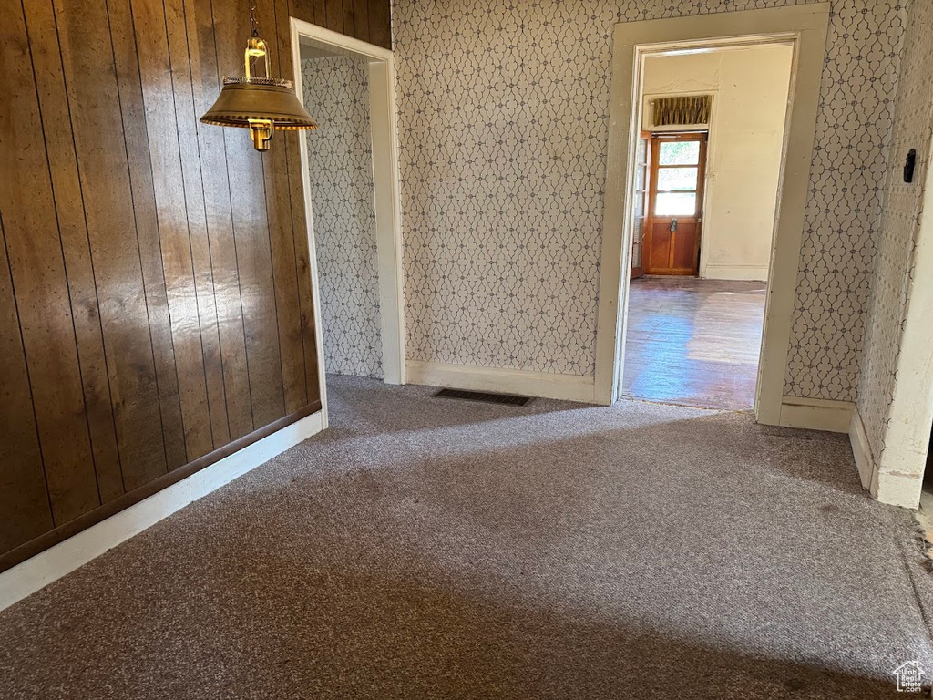 Unfurnished room with carpet flooring and wooden walls