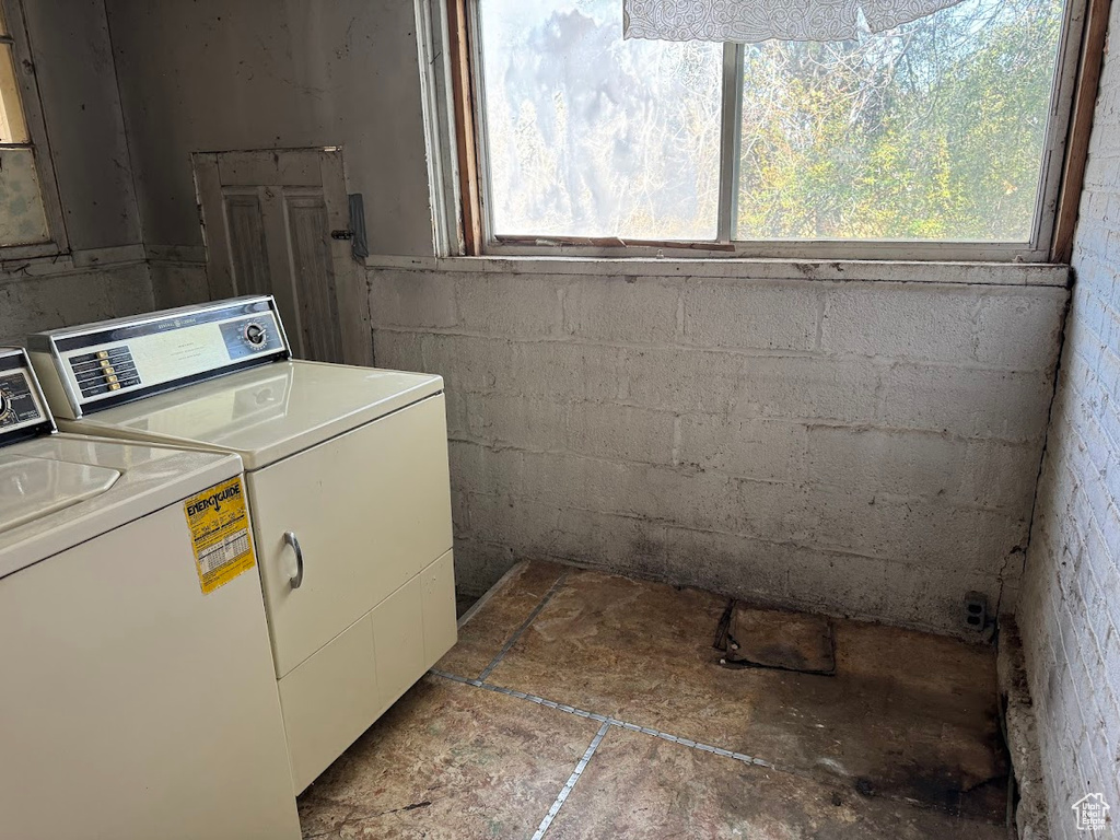 Clothes washing area featuring washing machine and clothes dryer and a wealth of natural light