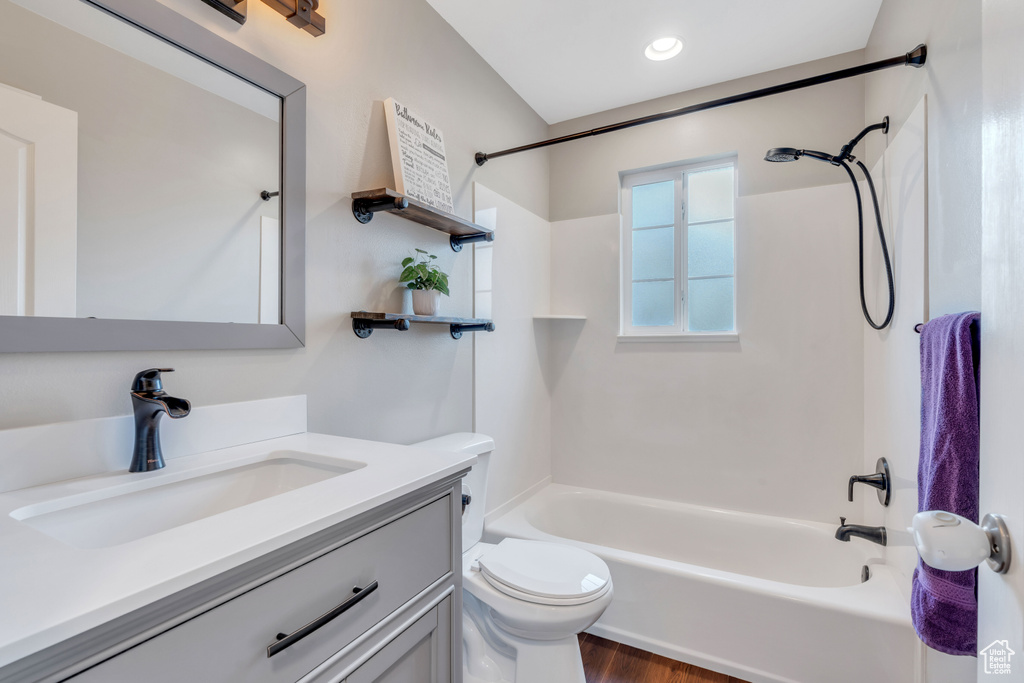 Full bathroom with washtub / shower combination, hardwood / wood-style flooring, vanity, and toilet