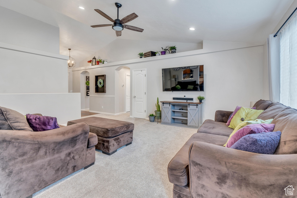 Carpeted living room featuring ceiling fan and lofted ceiling