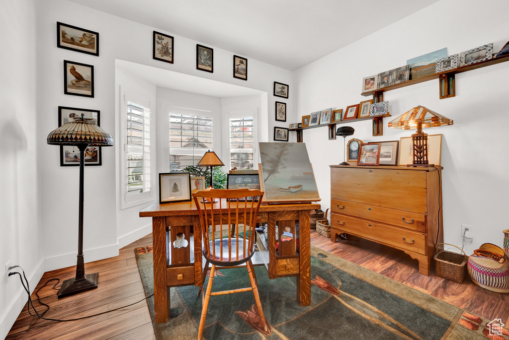 Home office with dark hardwood / wood-style floors
