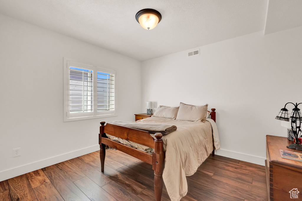 Bedroom with dark hardwood / wood-style floors