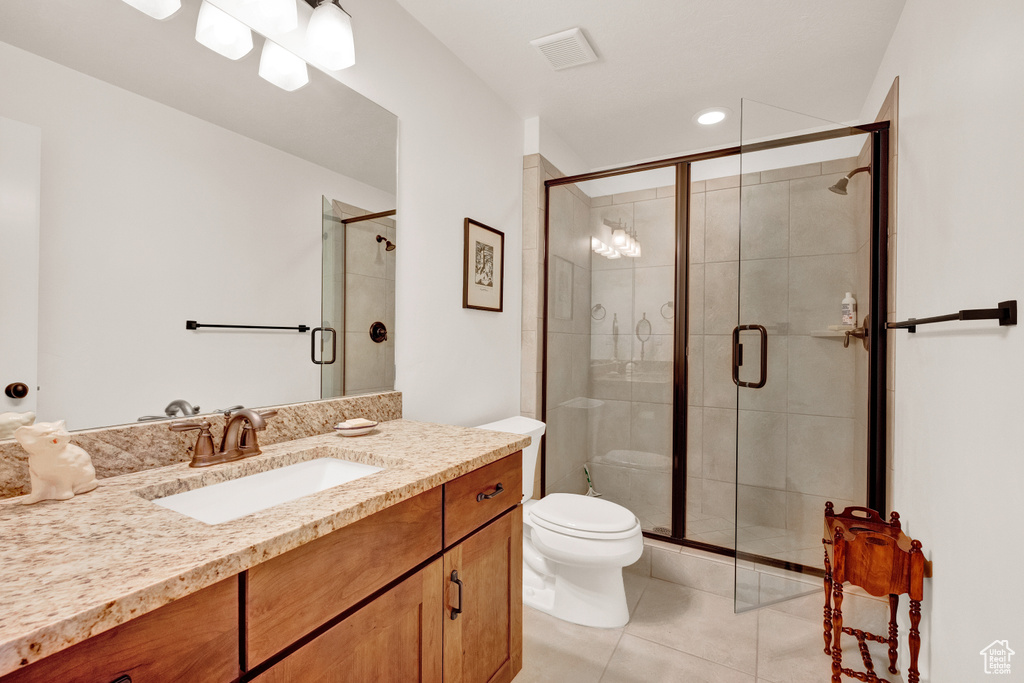 Bathroom featuring large vanity, a shower with shower door, tile floors, and toilet