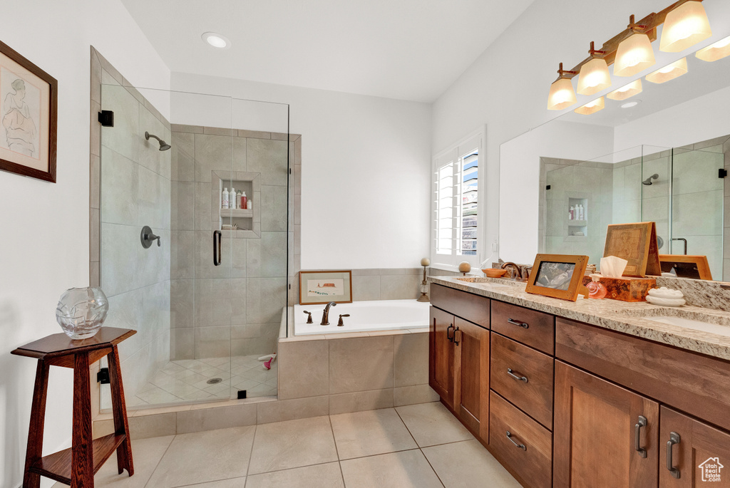 Bathroom with oversized vanity, dual sinks, tile floors, and separate shower and tub