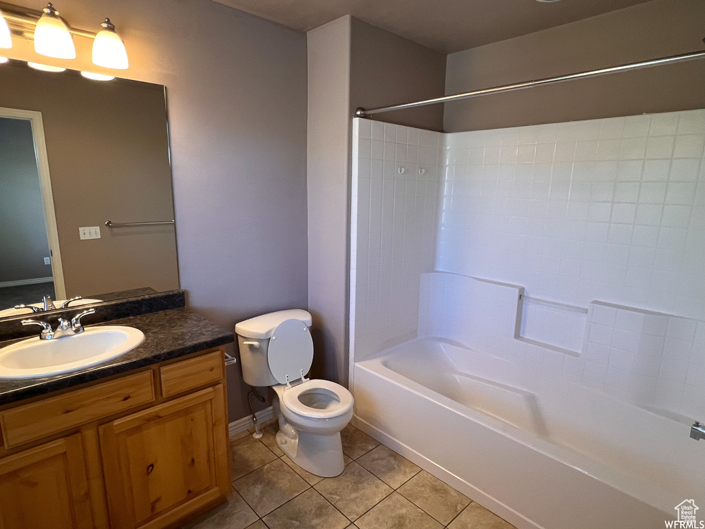 Full bathroom with bathtub / shower combination, vanity, toilet, and tile flooring