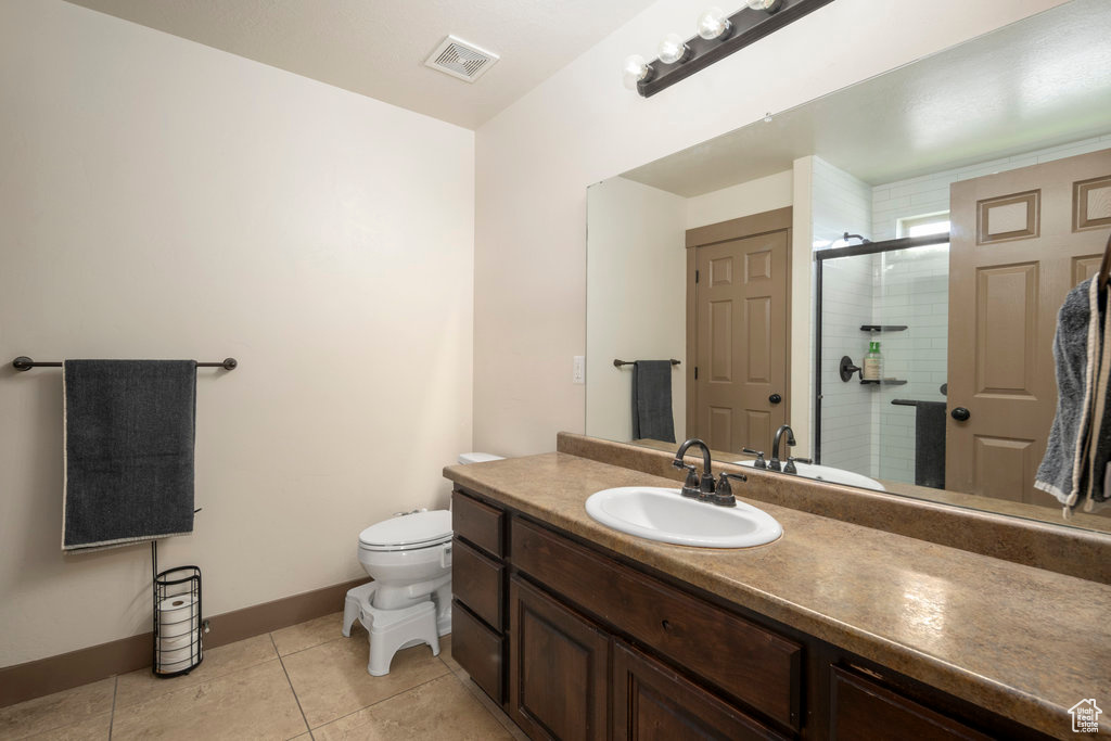 Bathroom with tile flooring, oversized vanity, and toilet