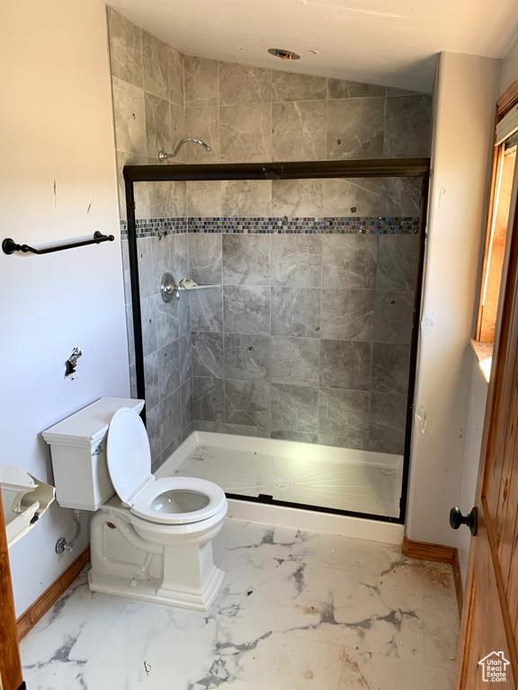 Bathroom featuring tile floors, toilet, and walk in shower