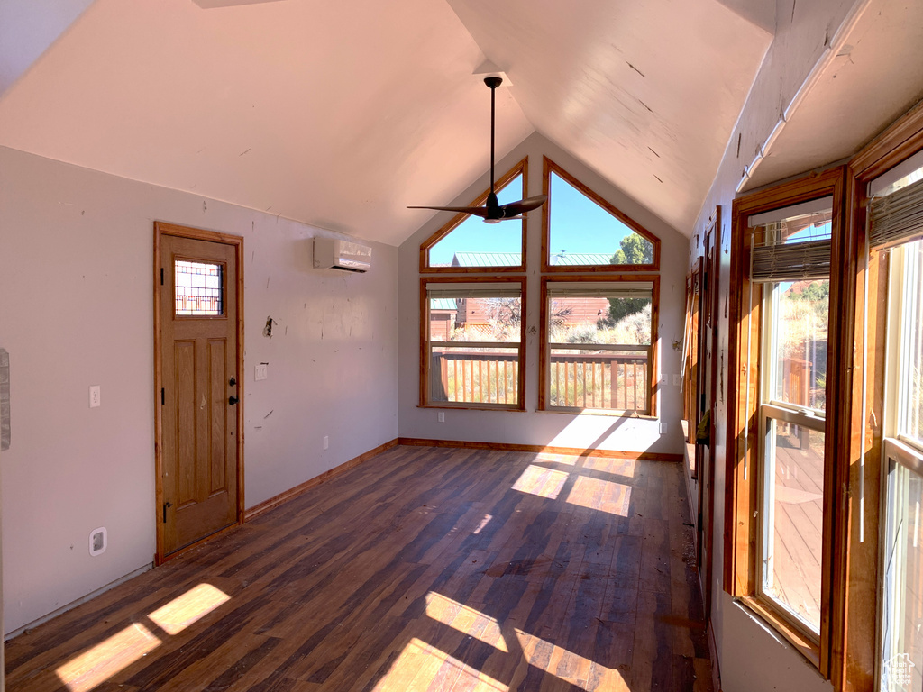 Unfurnished sunroom with lofted ceiling, a wall mounted AC, and ceiling fan