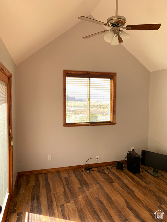 Spare room featuring dark hardwood / wood-style flooring, ceiling fan, and lofted ceiling