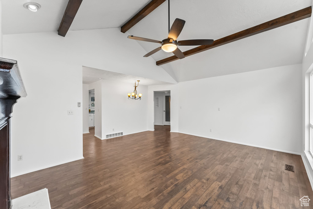 Unfurnished living room featuring ceiling fan with notable chandelier, dark hardwood / wood-style floors, beamed ceiling, and high vaulted ceiling