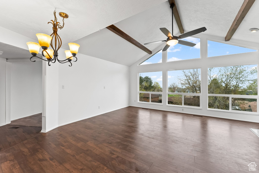 Unfurnished living room with beamed ceiling, ceiling fan with notable chandelier, high vaulted ceiling, and dark hardwood / wood-style floors