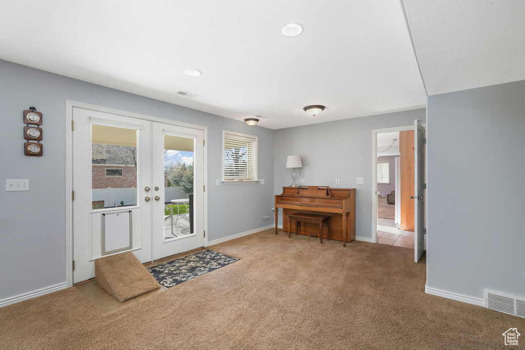 Foyer entrance featuring french doors and light colored carpet