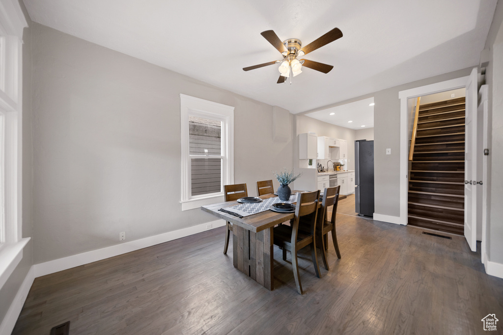 Dining space with dark wood-type flooring and ceiling fan