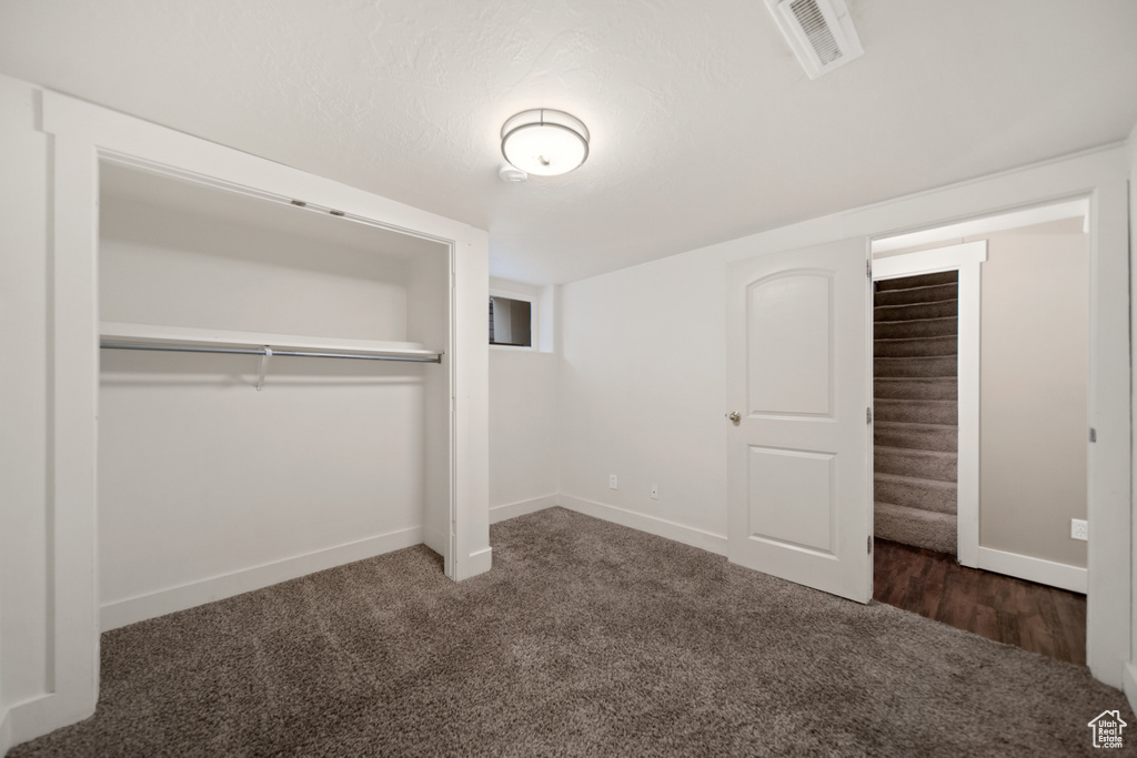 Unfurnished bedroom featuring a closet and dark hardwood / wood-style floors