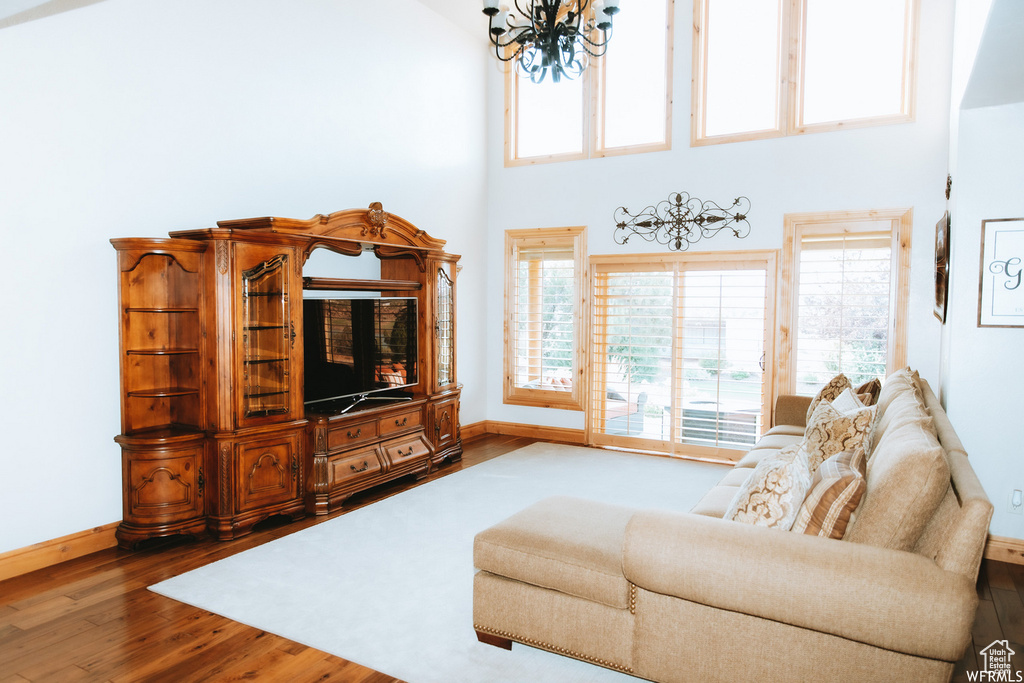 Living room featuring a chandelier, hardwood / wood-style flooring, and a towering ceiling