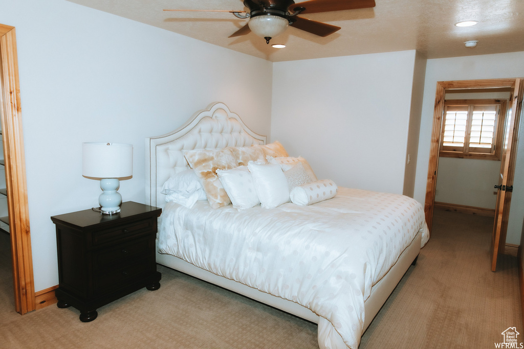 Bedroom featuring light colored carpet and ceiling fan