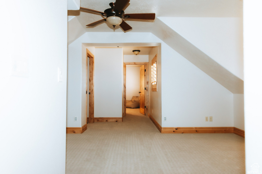 Bonus room featuring light carpet, ceiling fan, and lofted ceiling