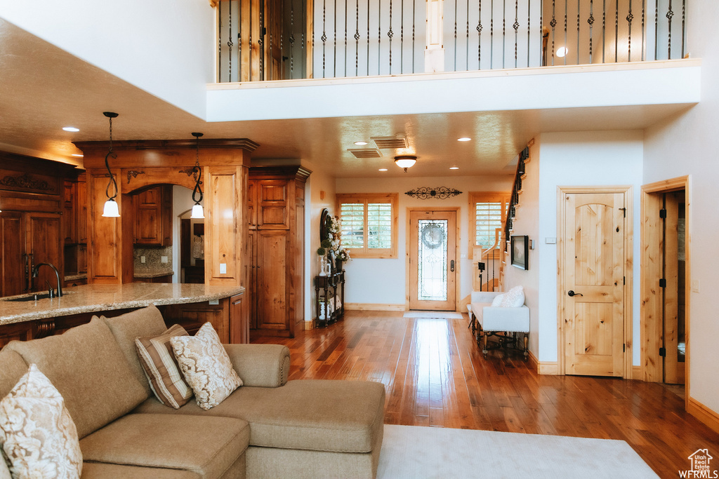 Living room with sink, a high ceiling, and dark hardwood / wood-style floors