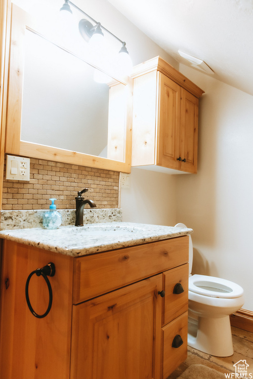 Bathroom with backsplash, hardwood / wood-style floors, vanity, and toilet