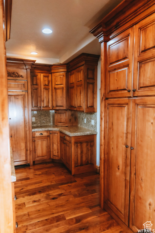Kitchen featuring backsplash and dark wood-type flooring