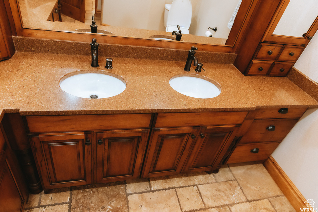 Bathroom with dual sinks, oversized vanity, and tile flooring