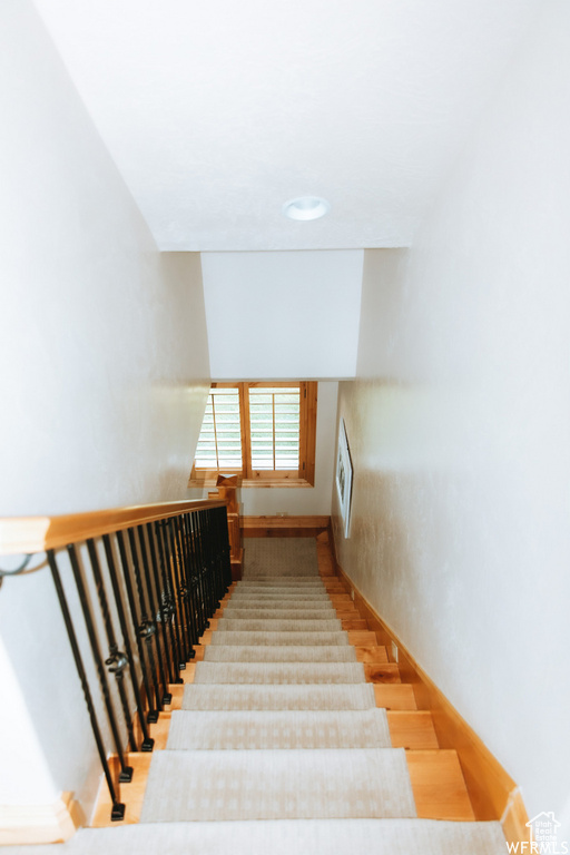 Stairway with light hardwood / wood-style flooring